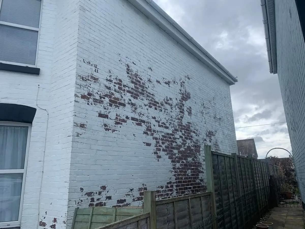 Peeling paint on a brick wall before redecoration in Launceston